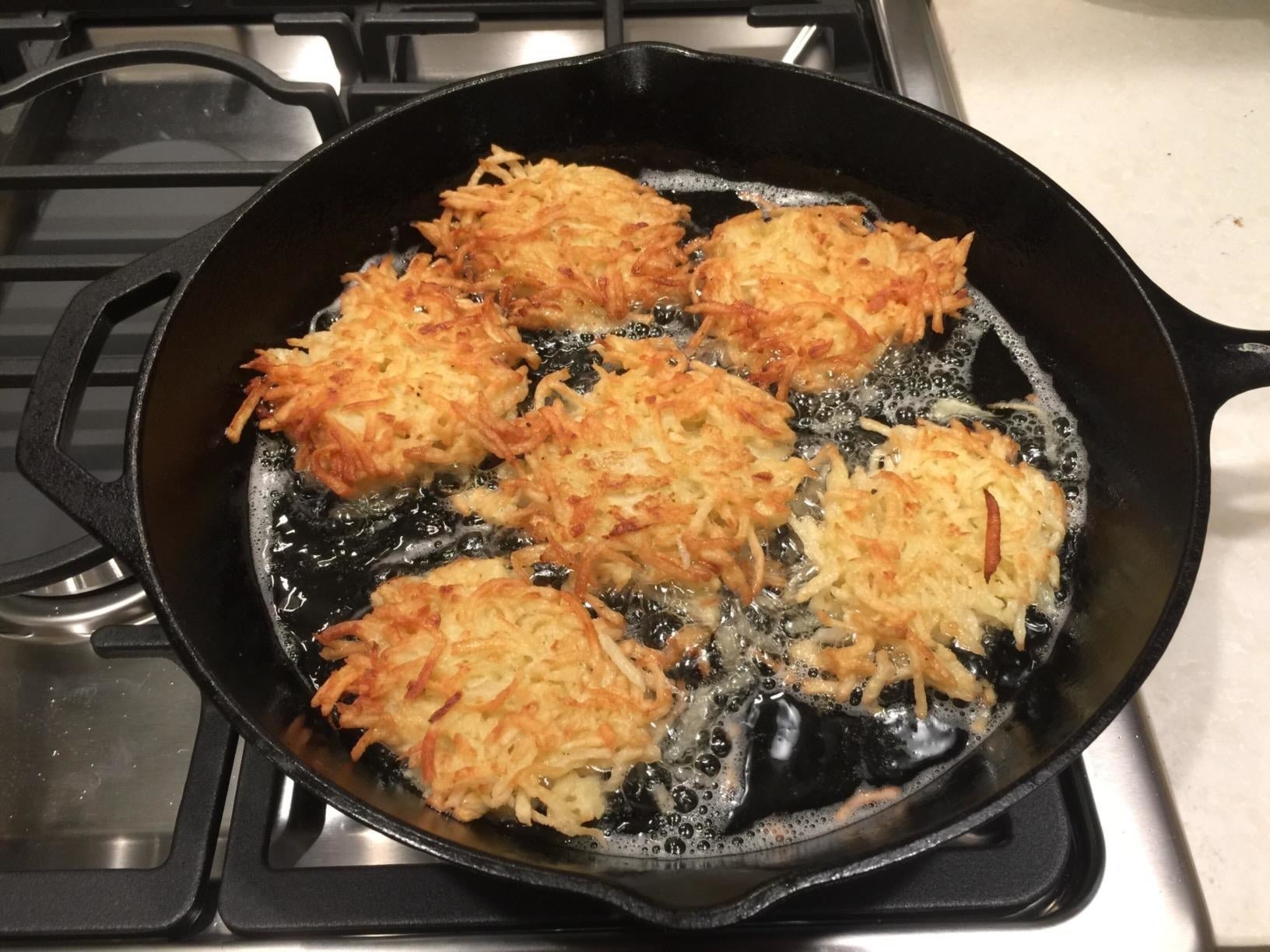 Reviewer image of latkes cooking in the skillet