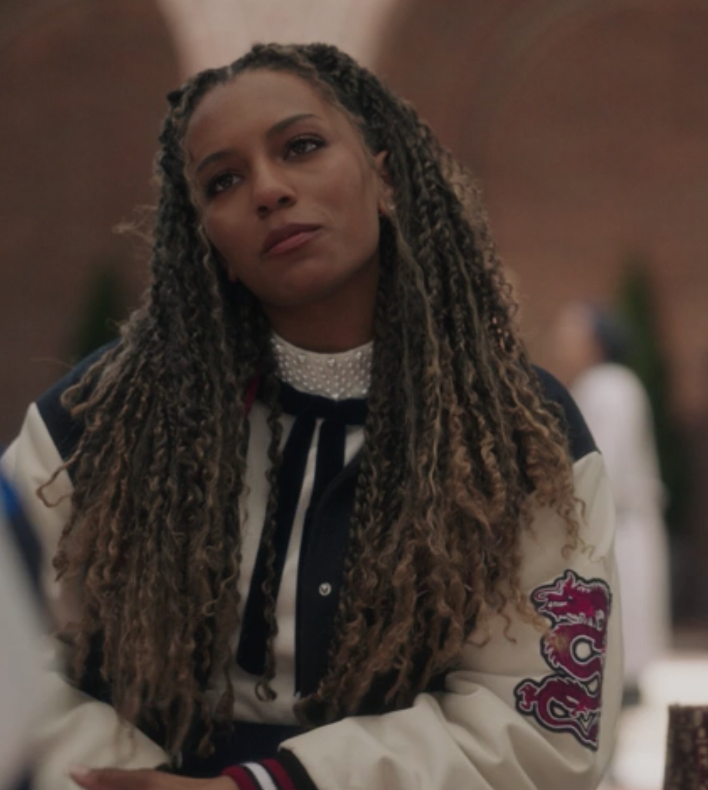 A close up of Monet Hann as she wears a letterman jacket with a dragon on the sleeve