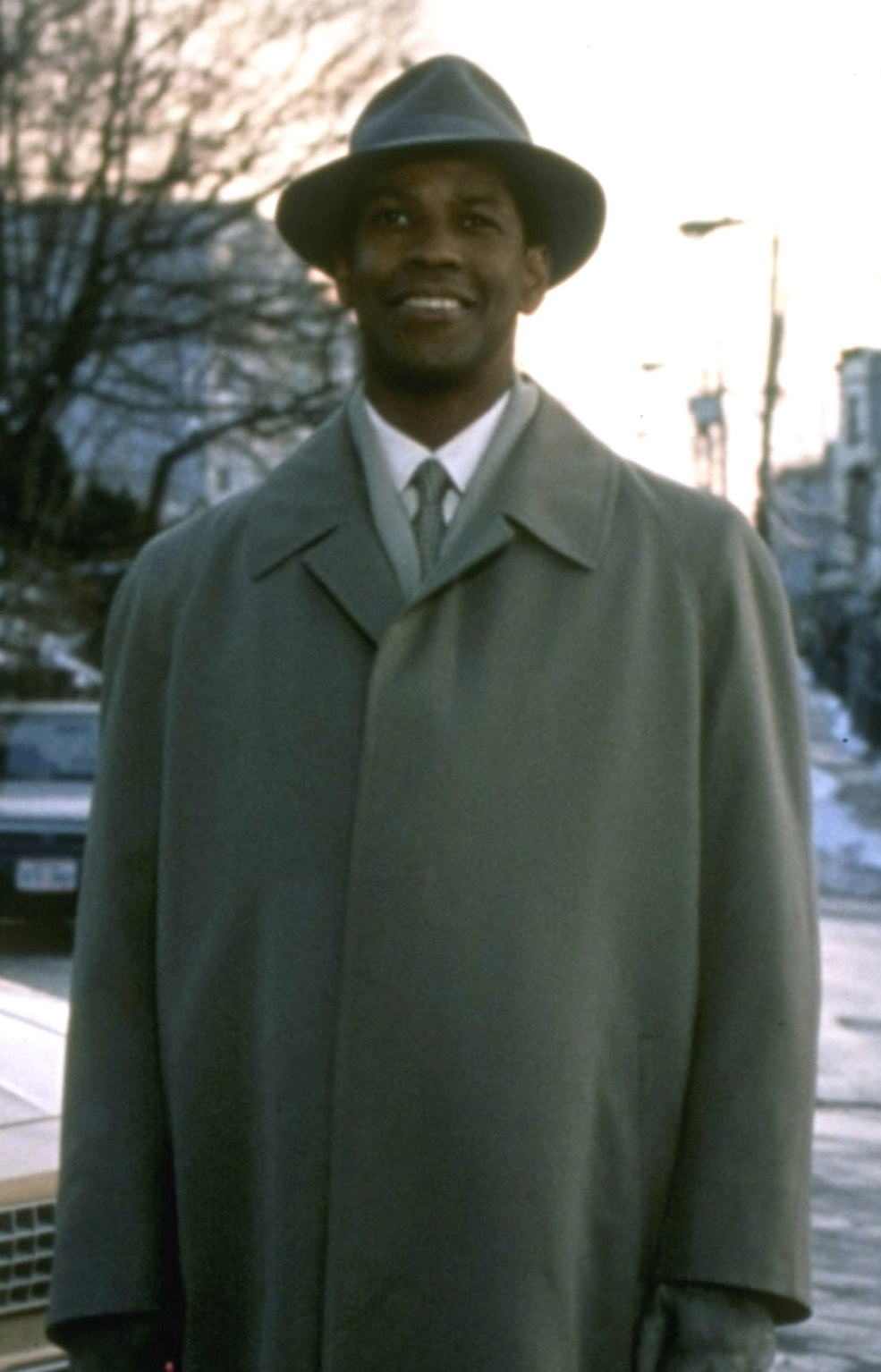 Washington standing happily in the cold, wearing a long coat and hat