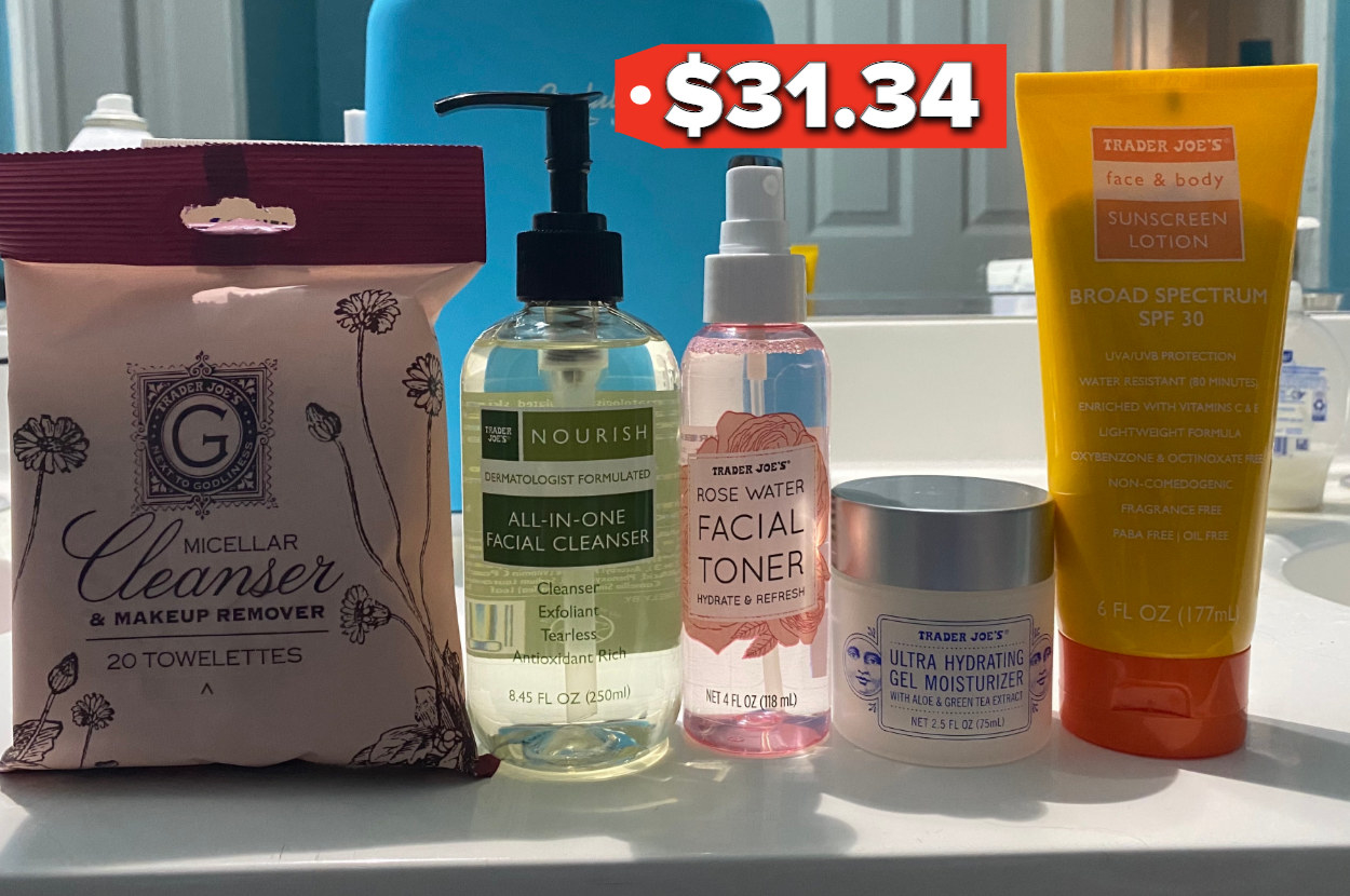 A package of cleansing towelettes sits next to a facial cleanser, toner bottle, moisturizer container, and sunscreen on a counter