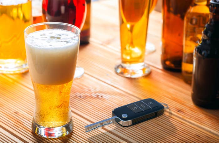 Car key on a bar next to a pint of beer