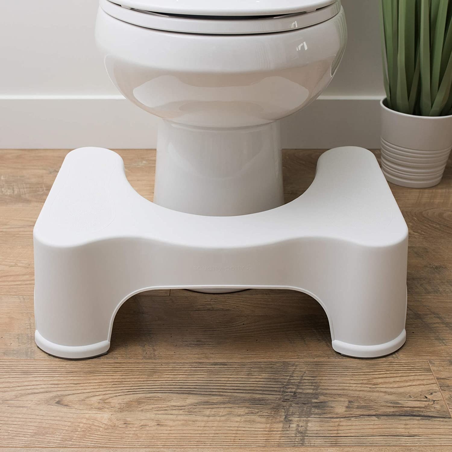 white squatty potty in front of a toilet