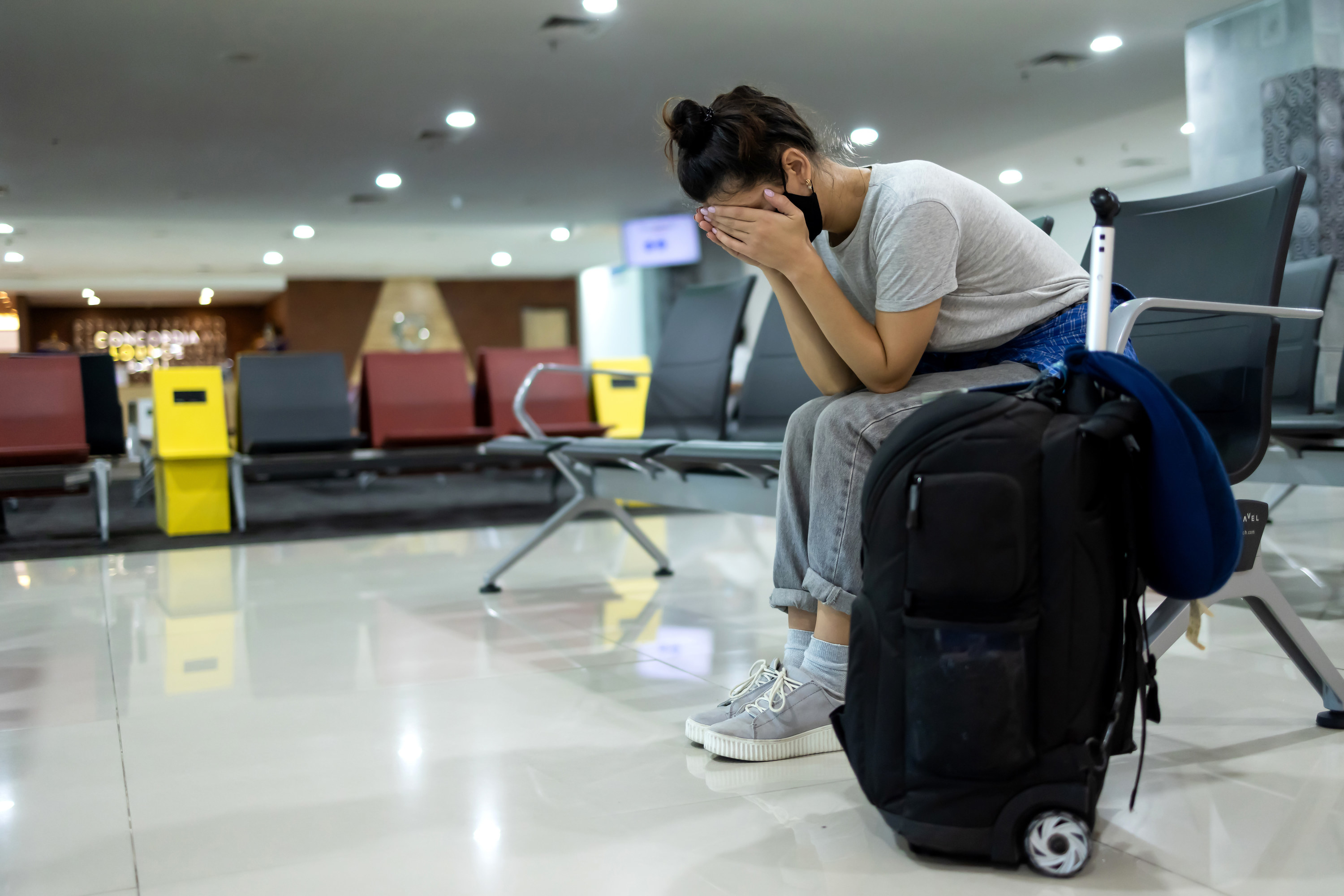 Woman stressing out at a train station with her bags