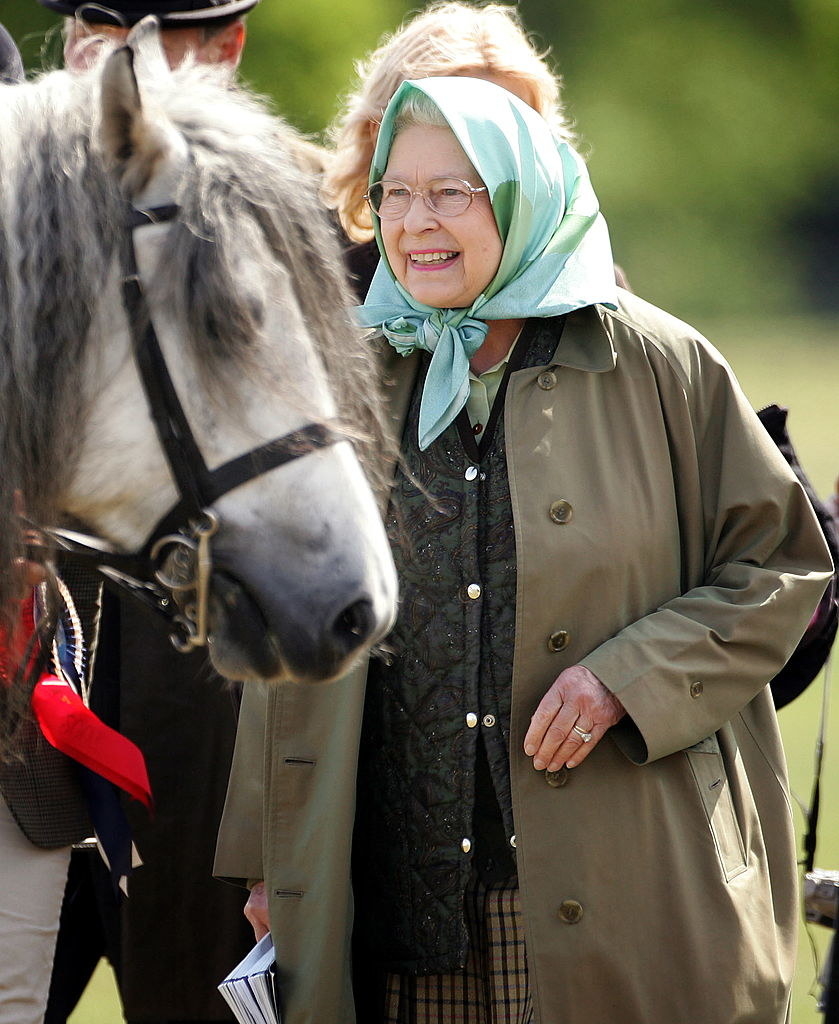 Queen Elizabeth II pats her horse Balmoral Melody as she attends the Royal windsor Horseshow