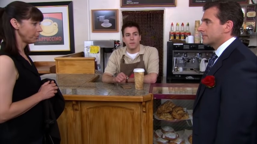 Michael standing in front of Pam&#x27;s landlady in a coffee shop in &quot;The Office&quot;