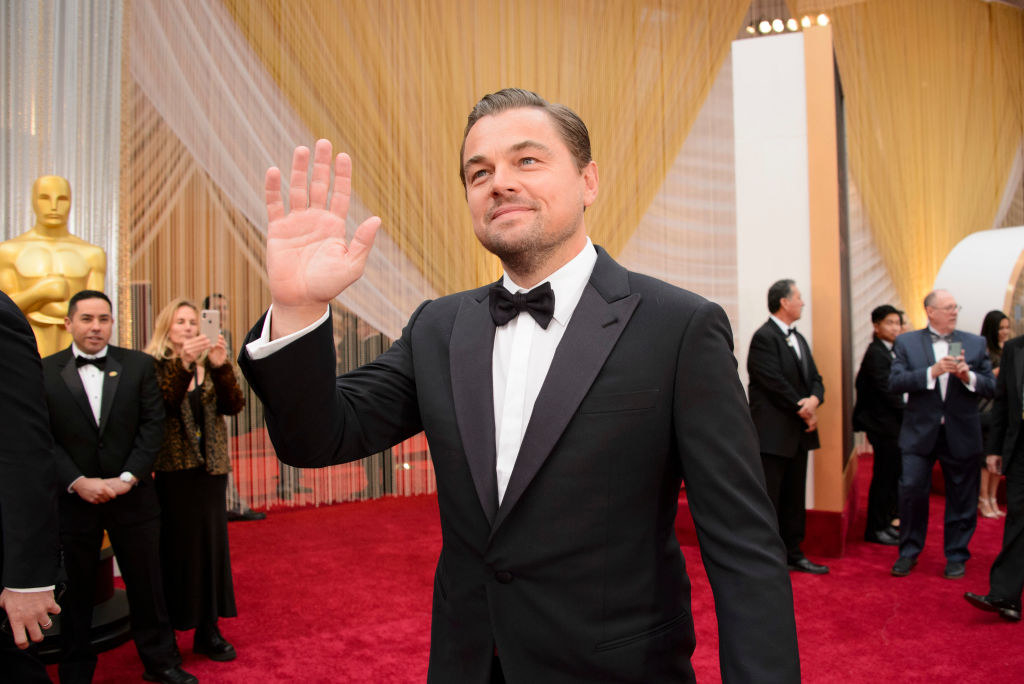 Leo waving his hand at the Academy Awards