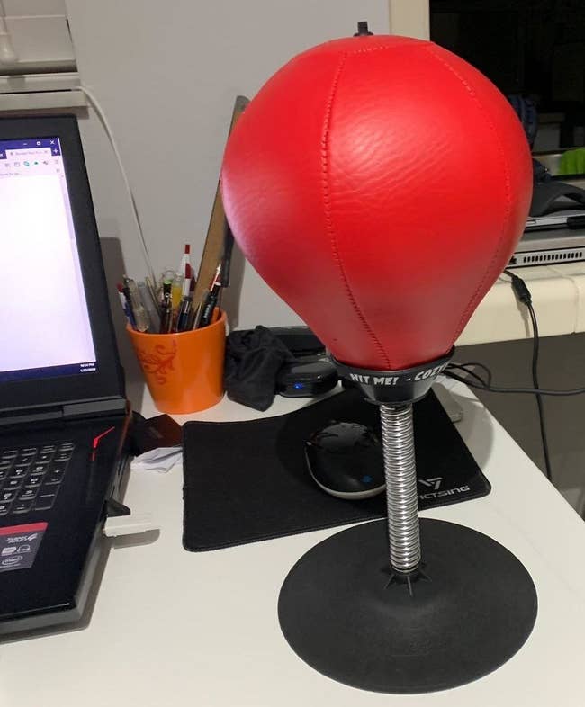 Punching bag with suction cup base on reviewer's desk