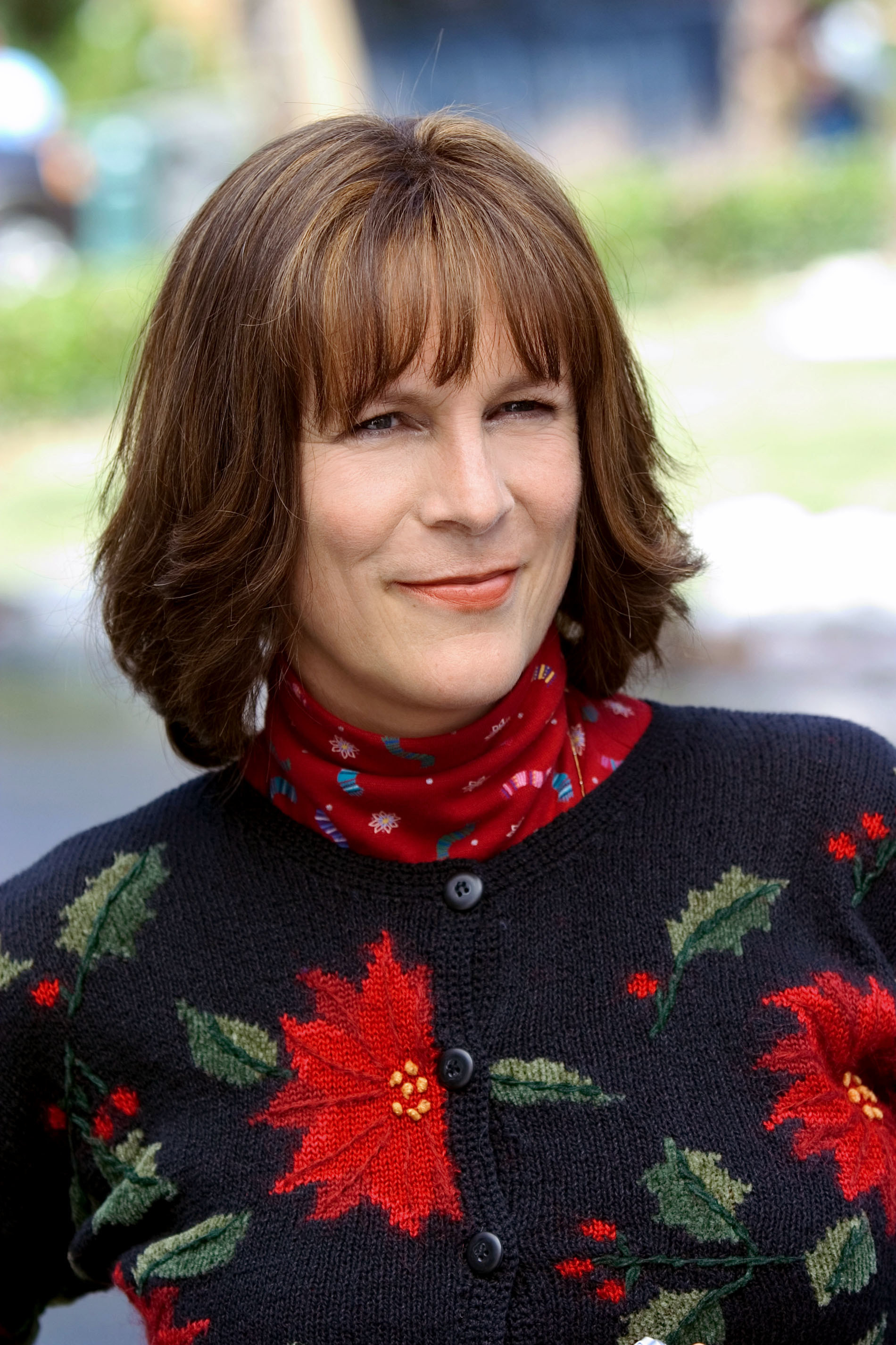 Curtis with long, brown hair and wearing a Christmas sweater