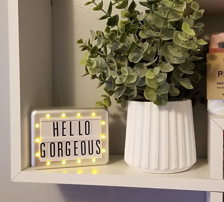 a sign with lights around the border that says hello gorgeous