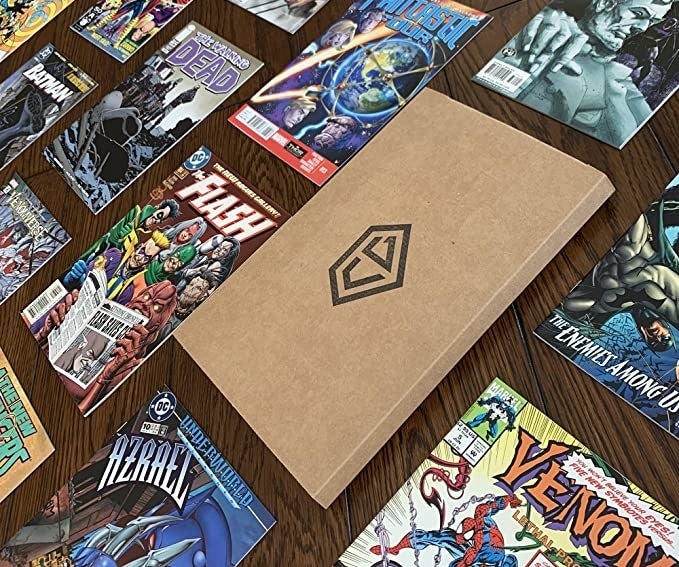 a slim cardboard box sitting on a table surrounded by different comic books