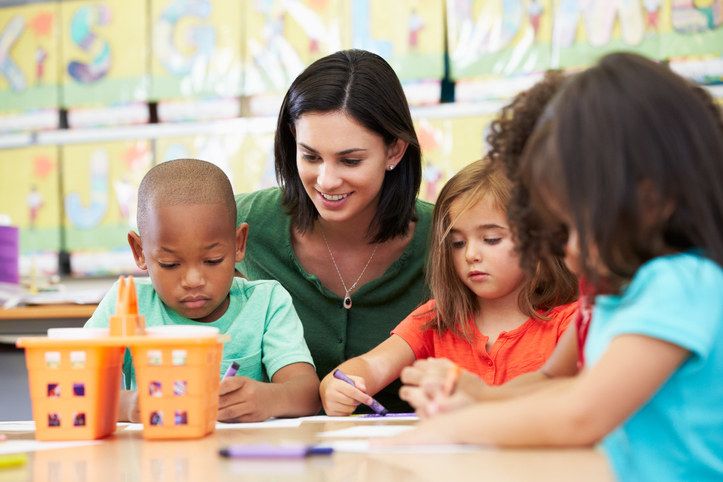 Teacher sitting beside a boy looking sad