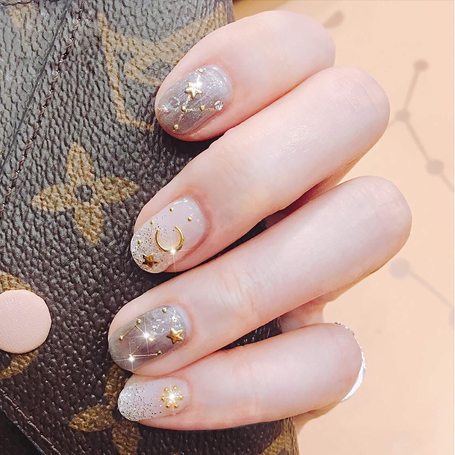 a close up of a person&#x27;s manicured nails with the metallic stickers on top