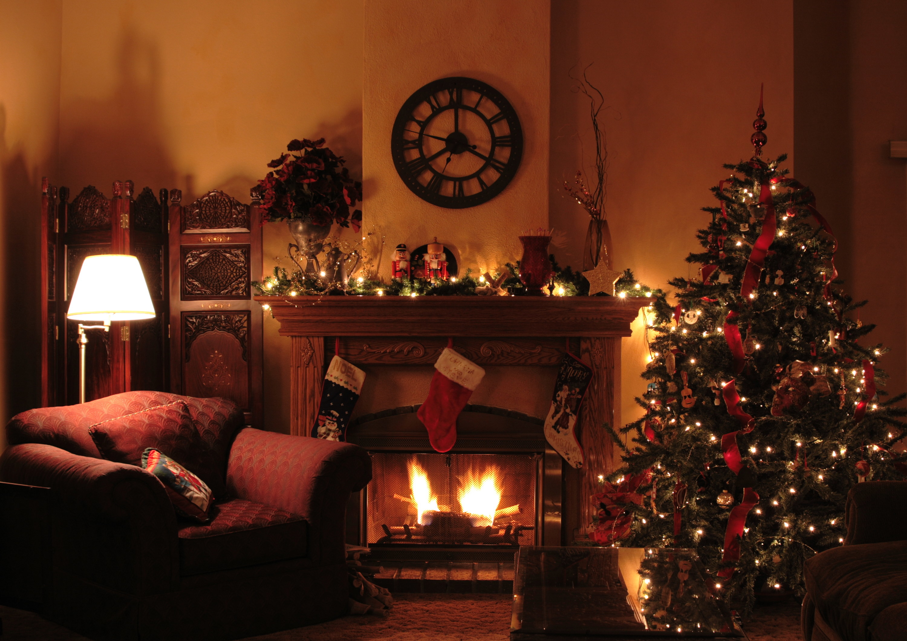 living room decorated for christmas with a clock over the mantle