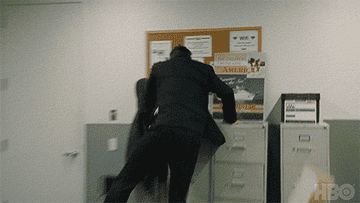 Tom from Succession freaking out in excitement by jumping on a cabinet and banging his chest