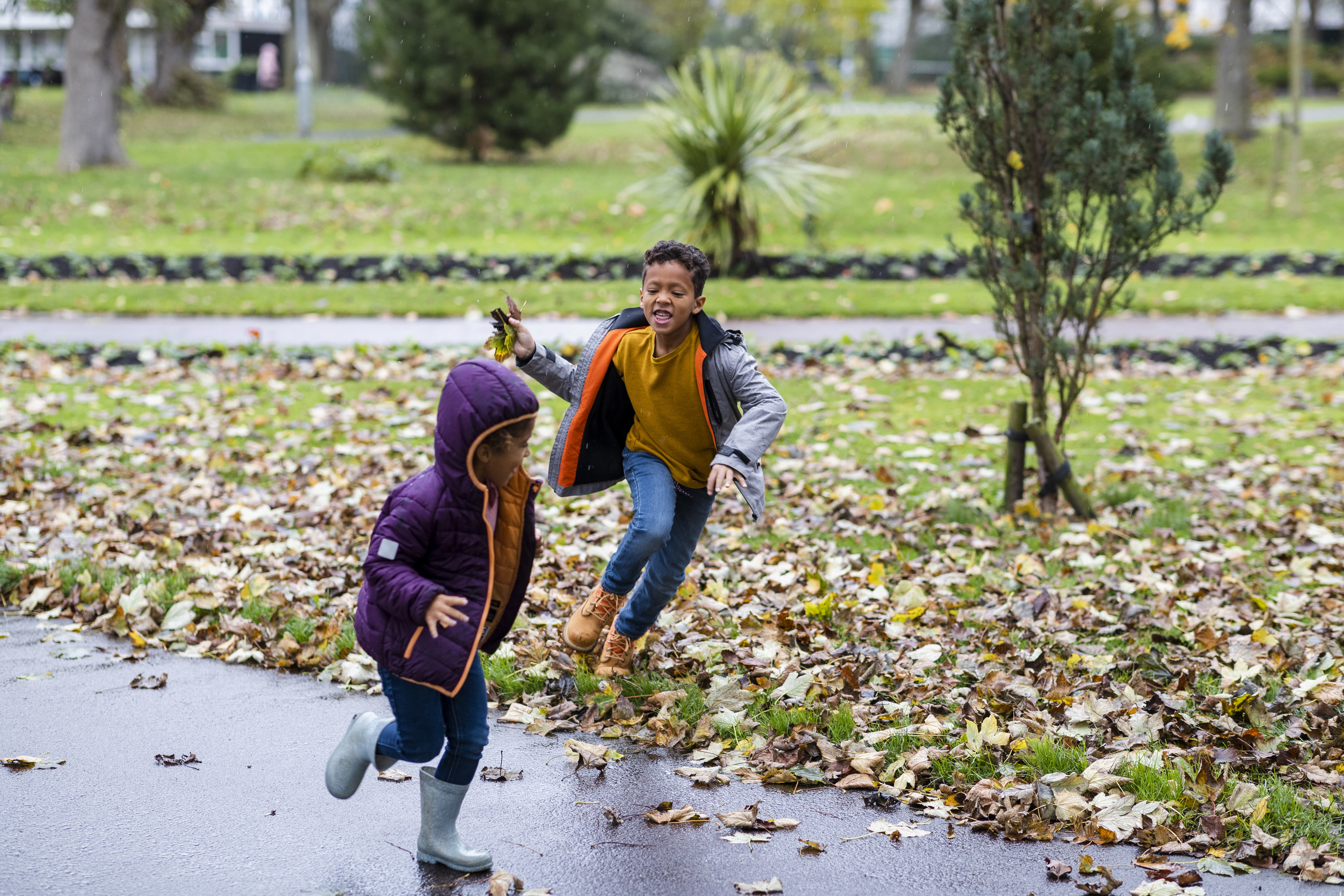 kids running through fallen leaves