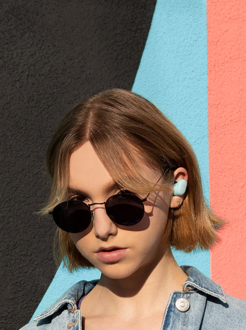 someone wearing the colourful ear buds while looking at the camera