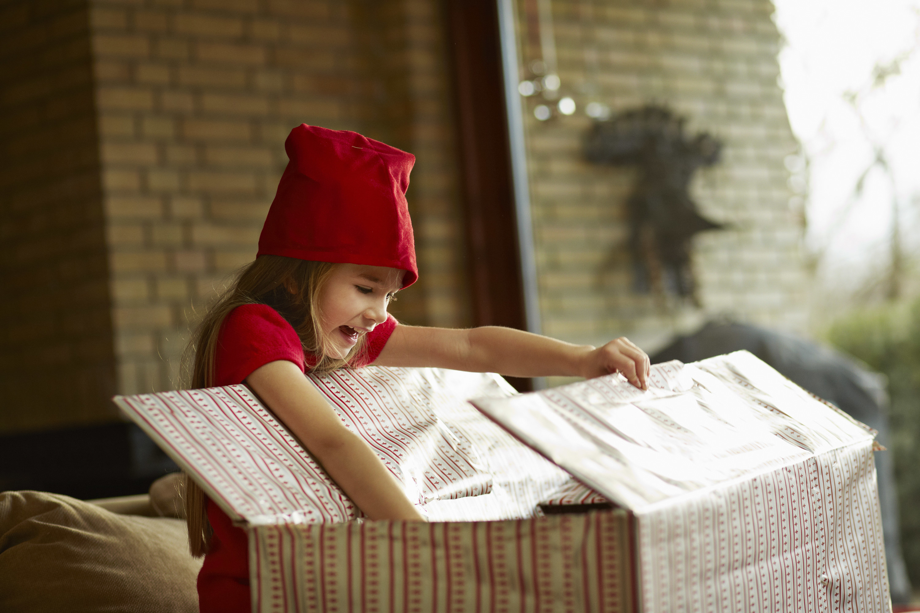 little girl looking into a giant christmas box