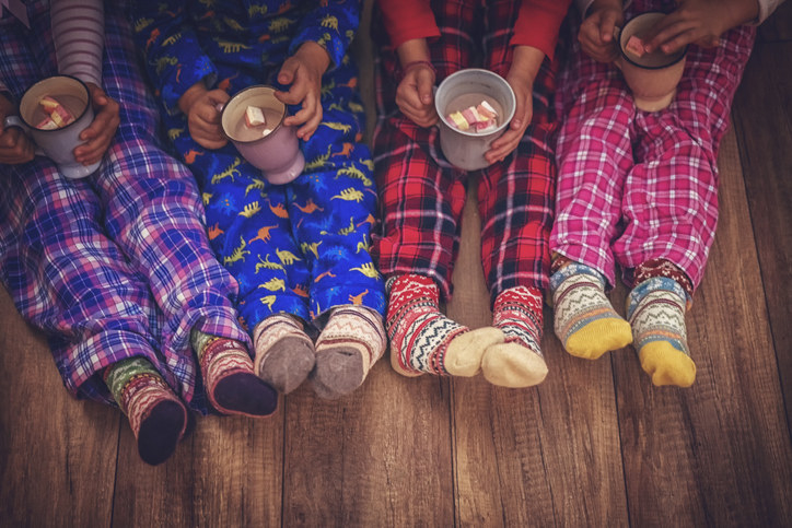Cute little kids in pajamas and Christmas socks drinking hot chocolate with marshmallows for Christmas