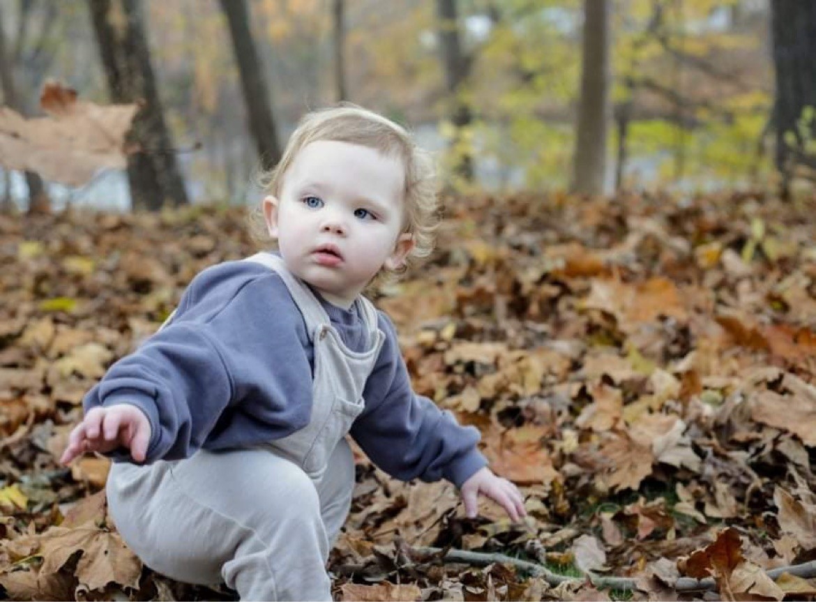 Marissa&#x27;s child playing with leaves outside