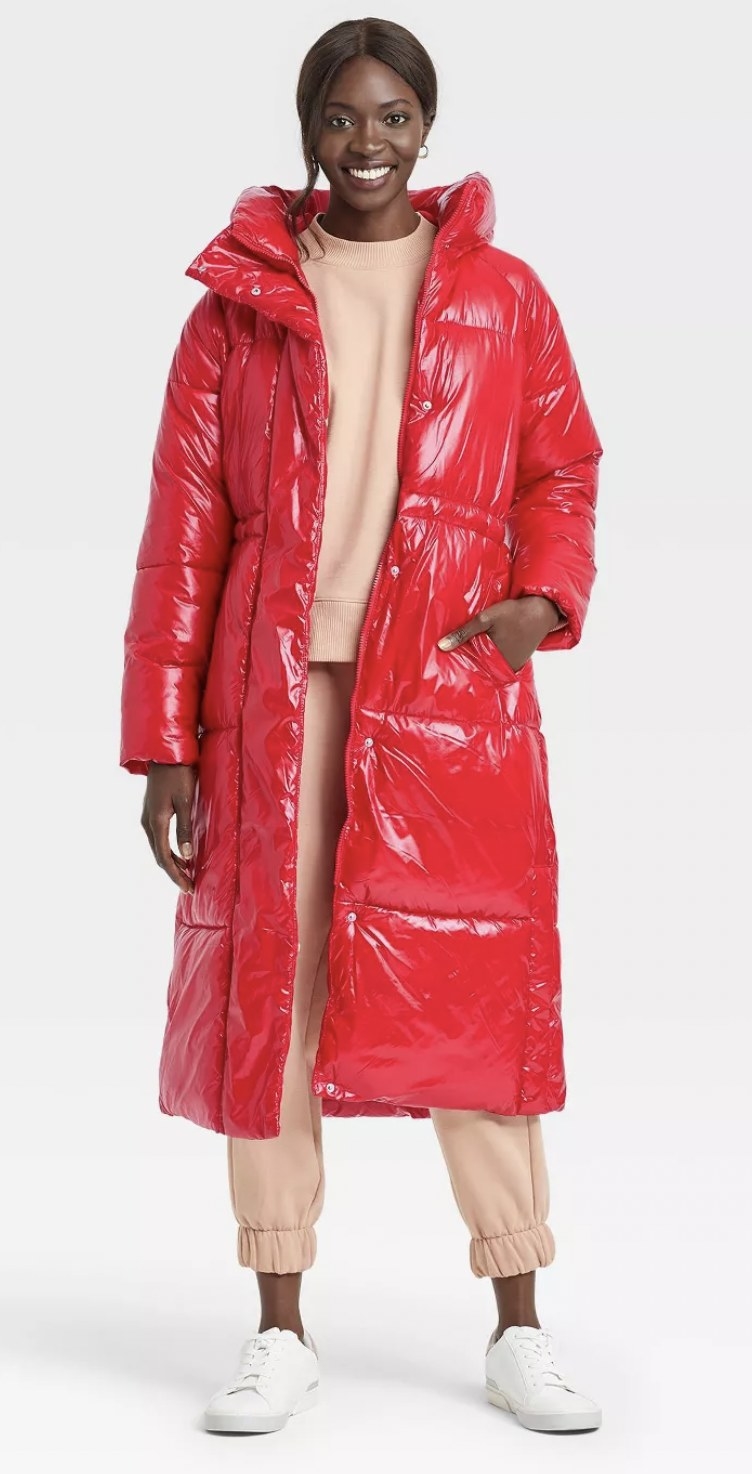 model wearing a past-the-knee puffer jacket in a glossy fire truck red color