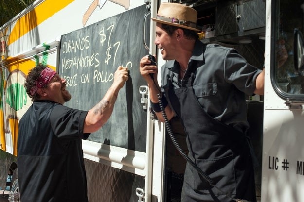One chef announcing while the other writes the menu on a chalkboard