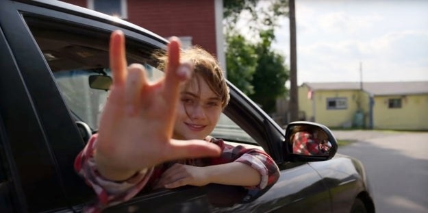 The daughter doing a sign from outside the car window