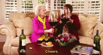 Betty White drinking a large glass of wine.