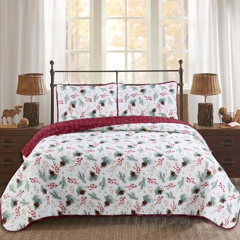 White quilt set on bed with green and red holly berry design