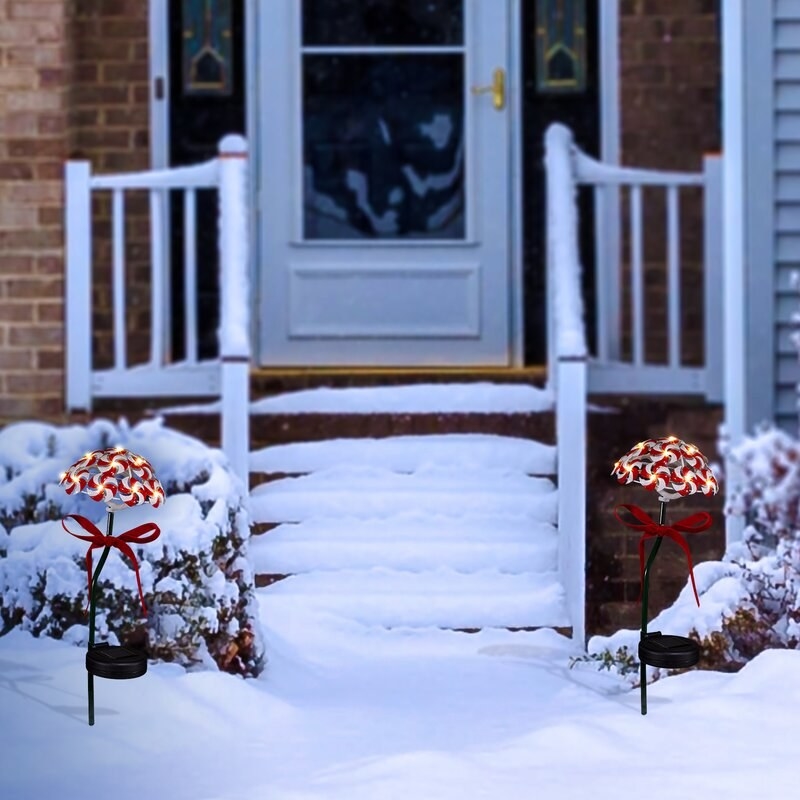 Light up peppermint garden stakes on either side of snowy walkway in front of house