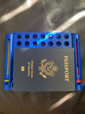 reviewer's photo showing their passport on top of the blue game