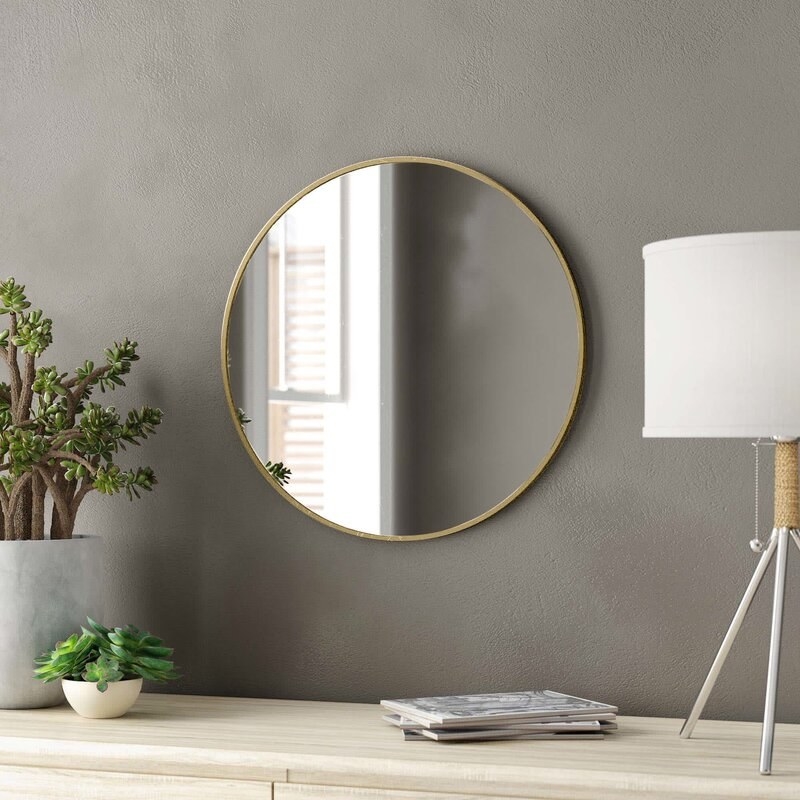 A accent mirror with a gold finish