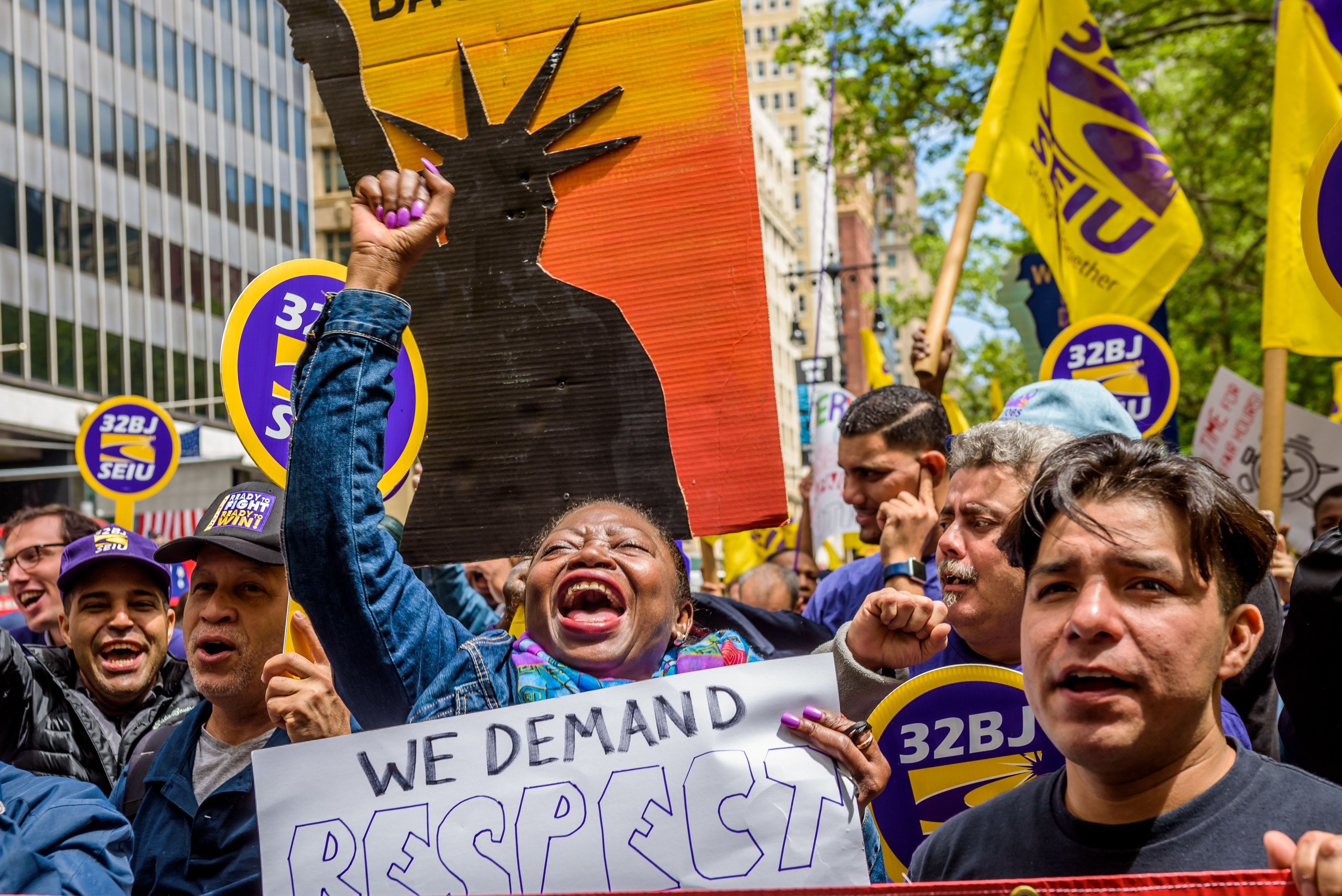 Fast food workers marching with a sign that says we demand respect