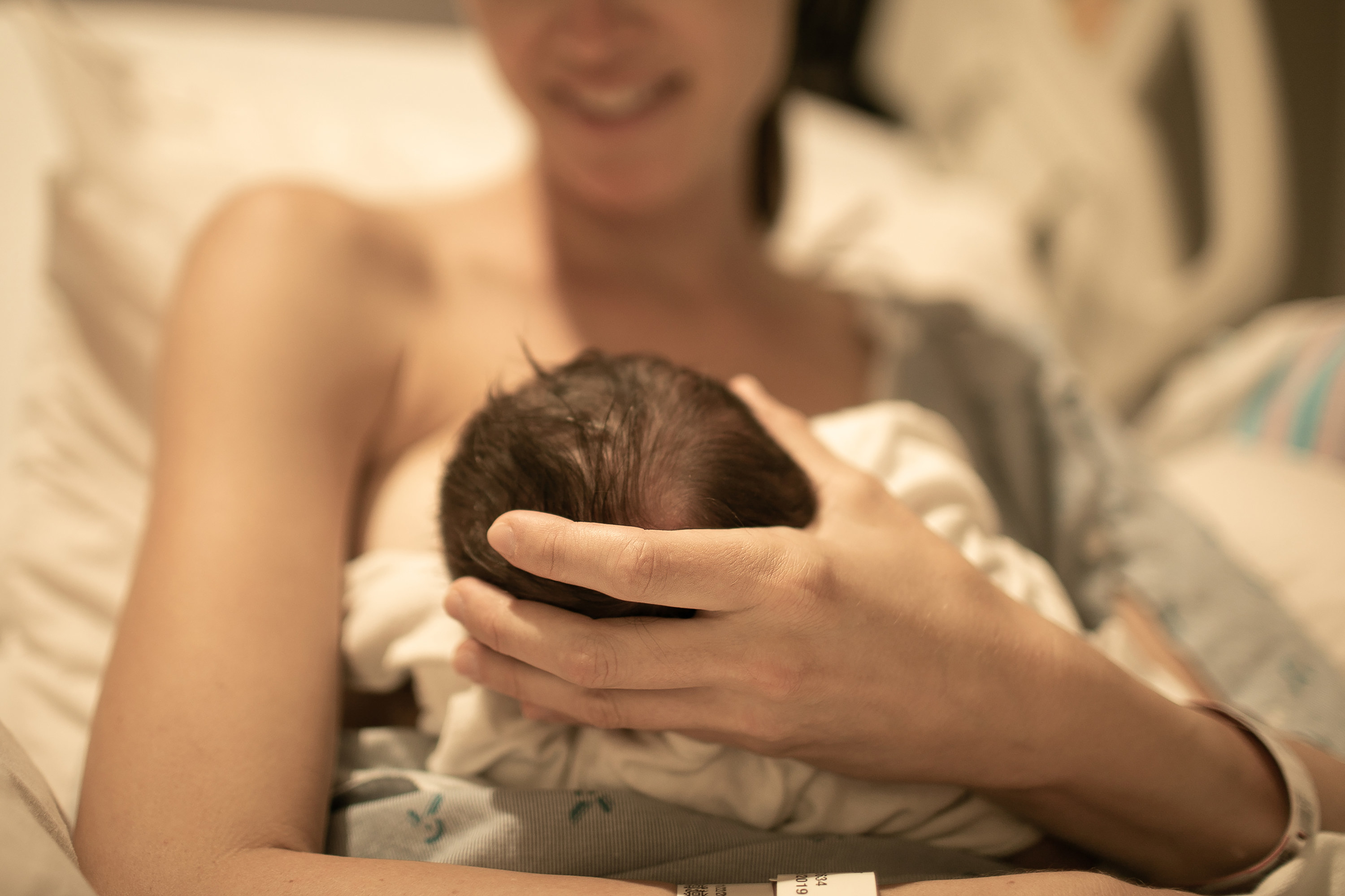 A mother holding a newborn in her hands in the hospital