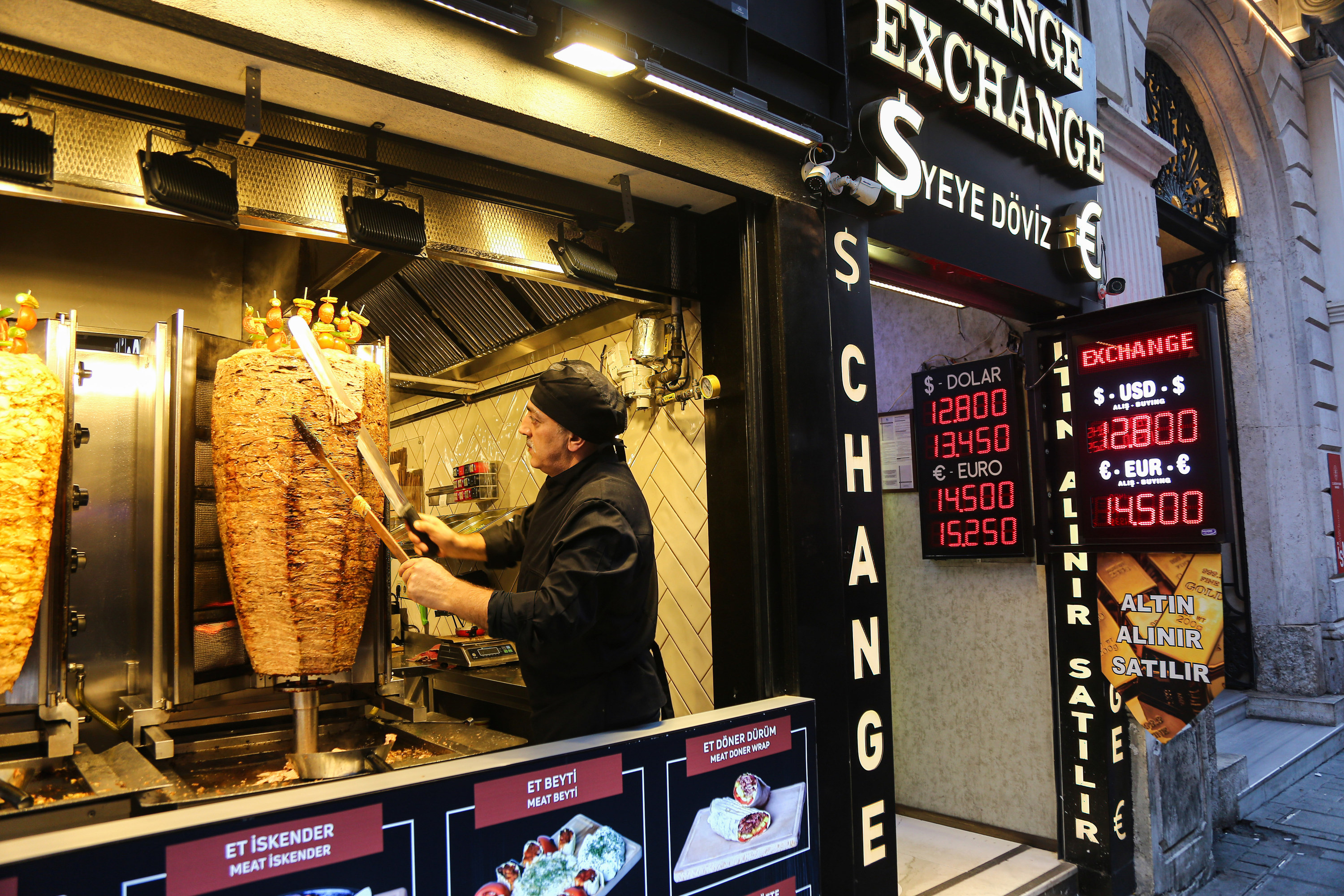 Kitchen staff is seen cutting cooked meat for a doner kebab dish at a restaurant in Beyoglu.
