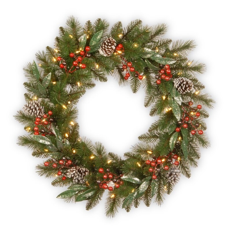 Green lighted wreath with red berries and frosted pine cones