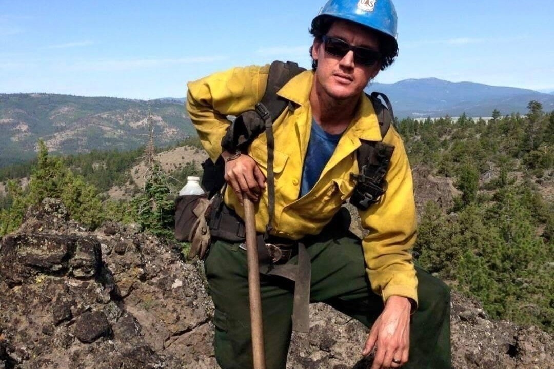 A man in a firefighter uniform in the wilderness