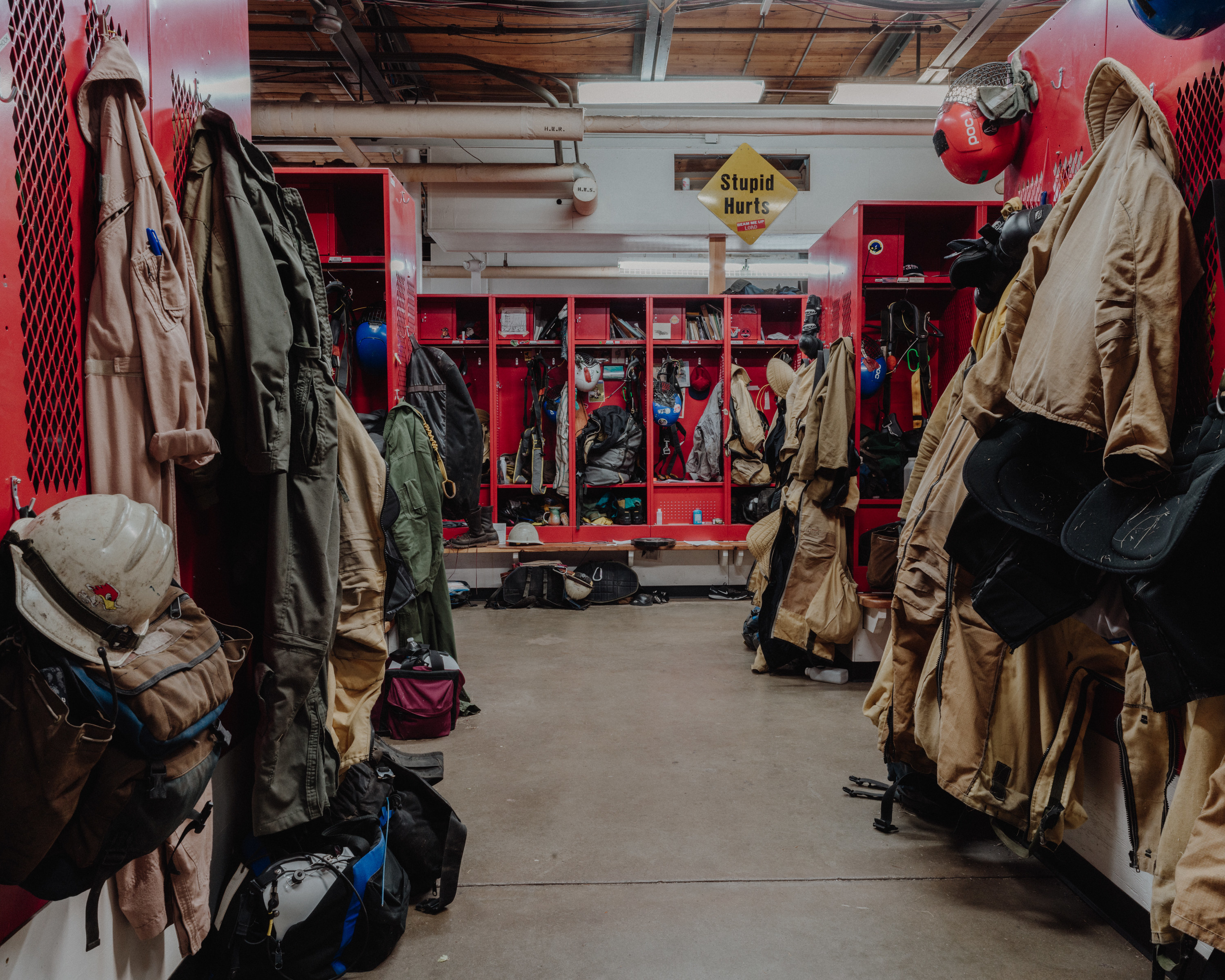 A locker room filled with firefighter equipment and a sign that reads &quot;stupid hurts&quot;