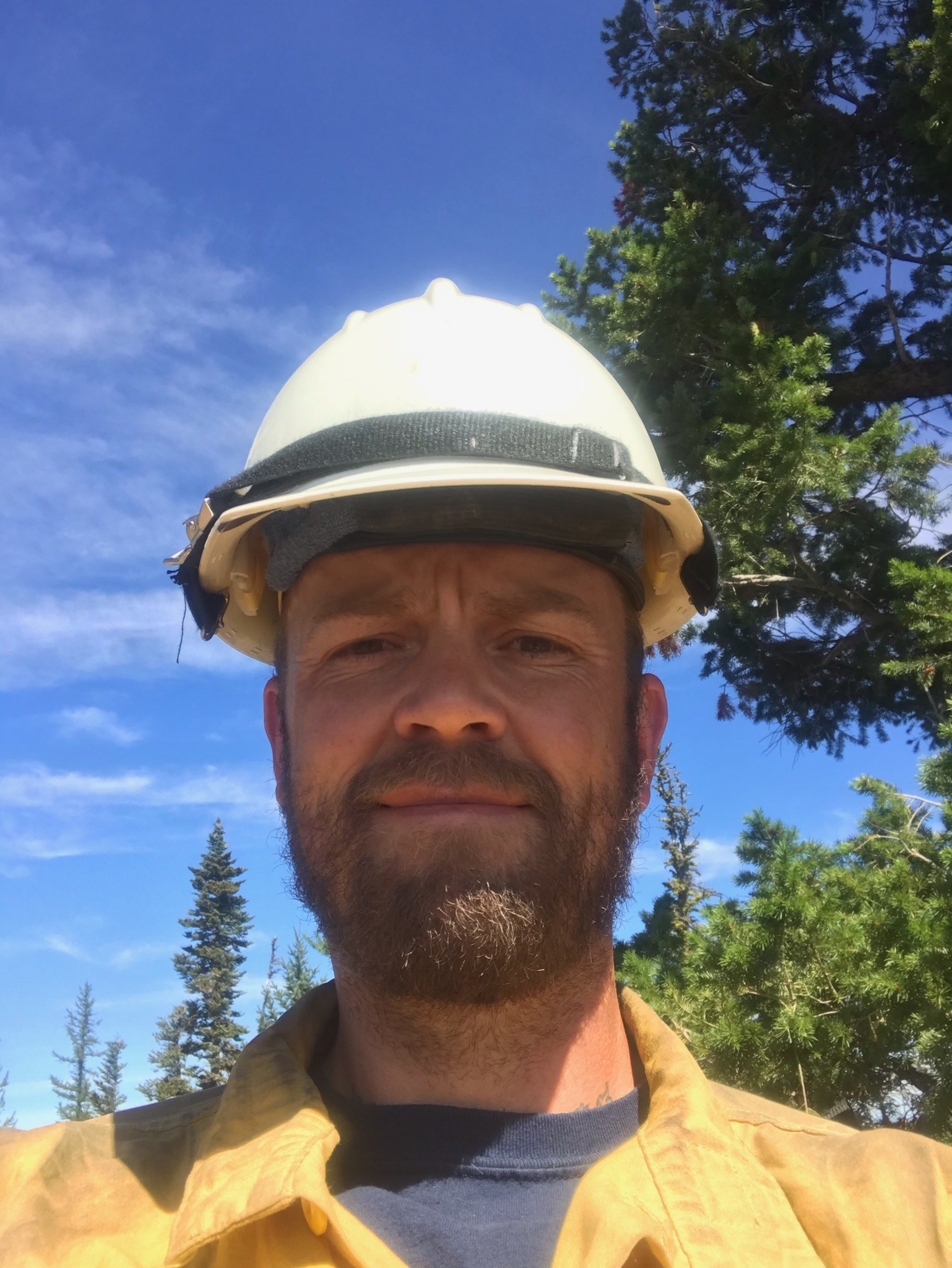 A man in a yellow shirt and a firefighter helmet