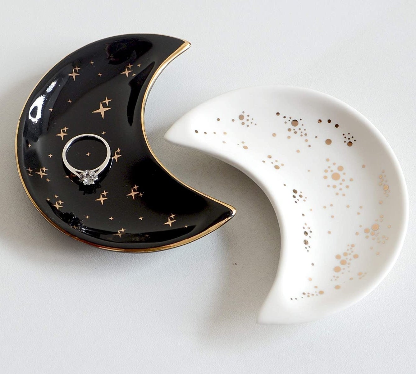 The black and white moon trinket dishes holding a ring