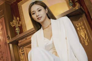 Tzuyu poses in front of a portrait in the music video for her cover of Taylor Swift's 'me'