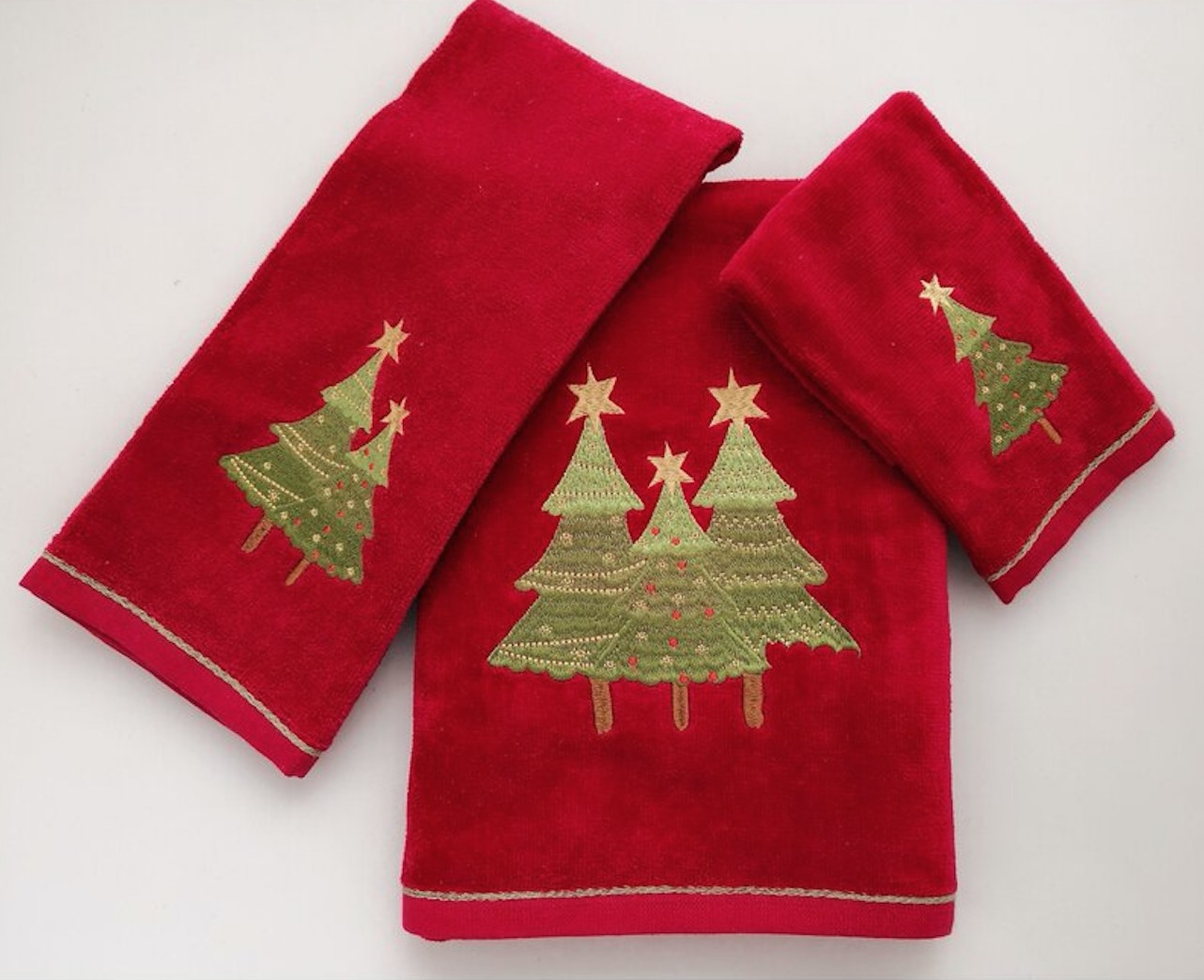 three red tea towels with embroidered trees