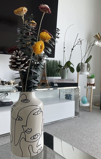 Reviewer photo of the vase holding some dried flowers on a living room table