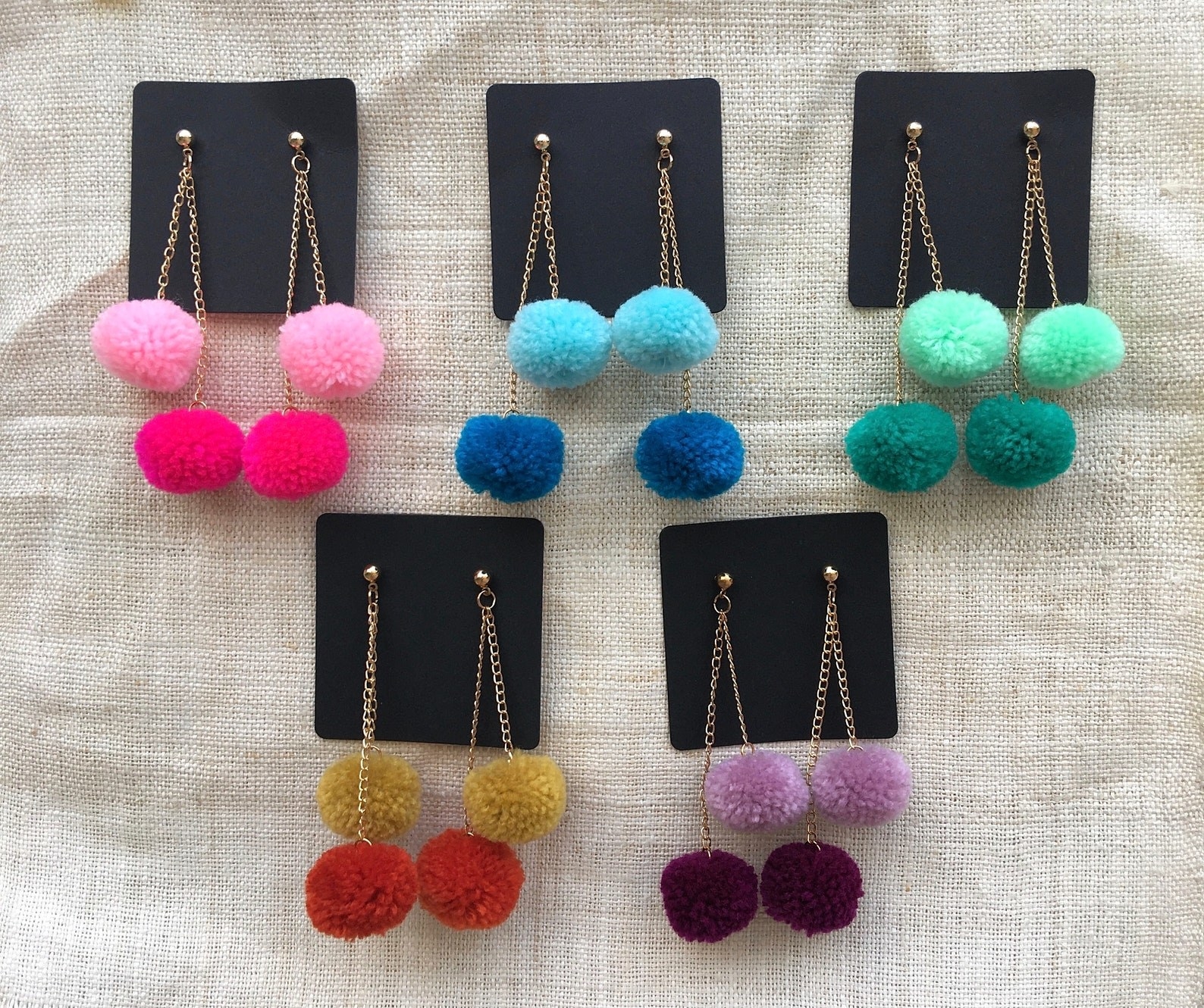 An array of pompom earrings in different colors