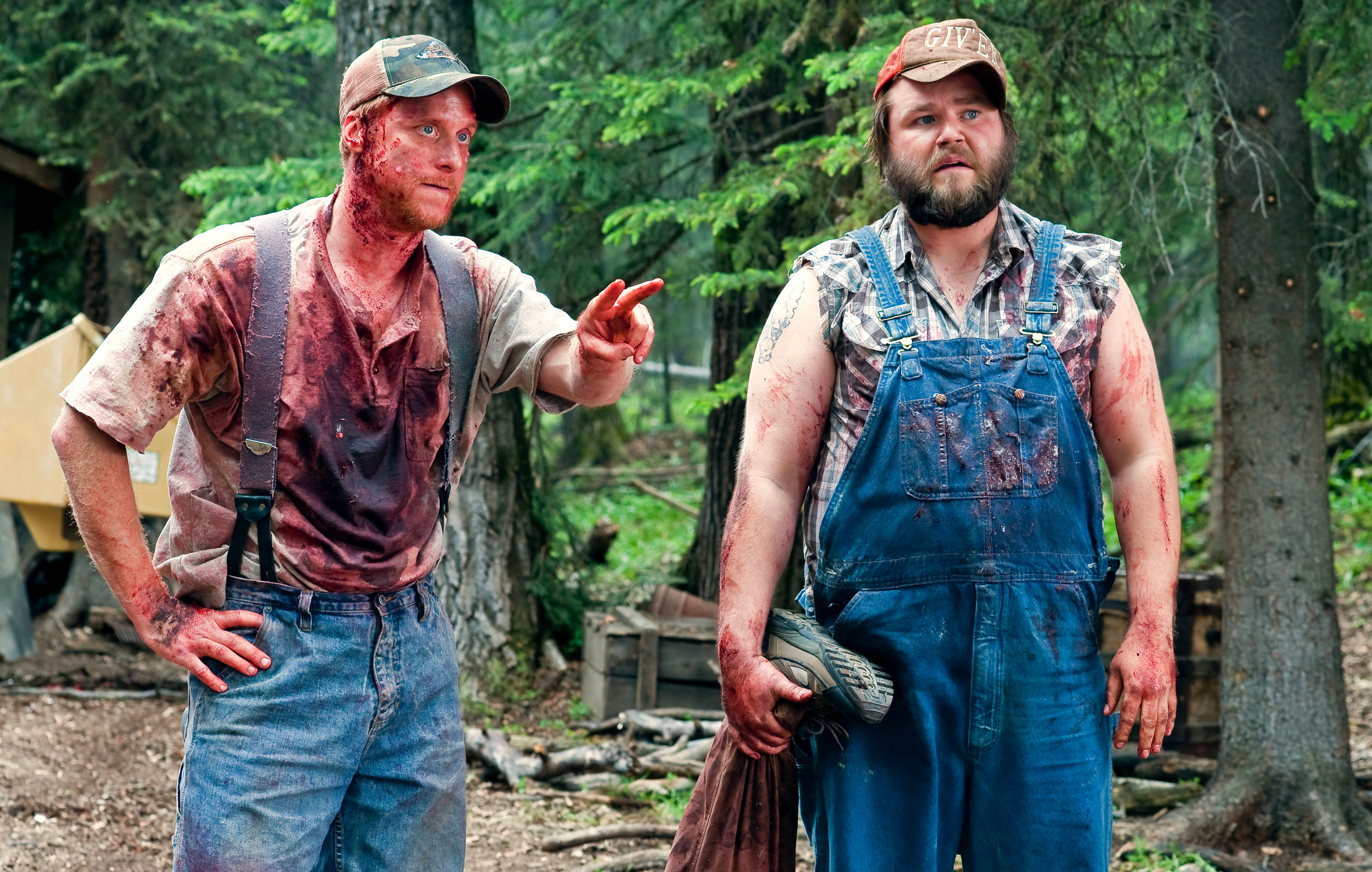 Alan Tudyk, Tyler Labine dressed in overalls and trucker hats, covered in blood