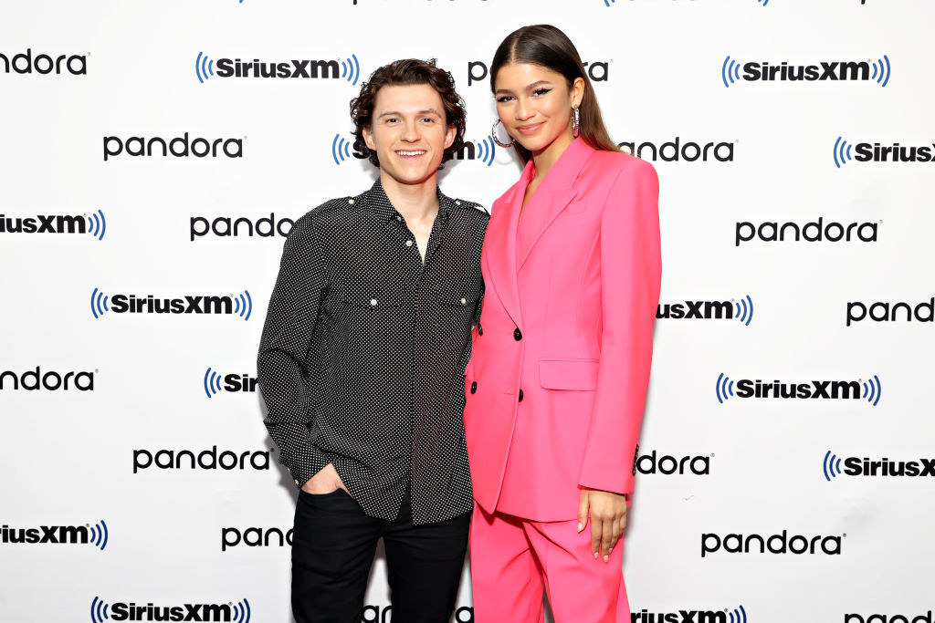 Tom and Zendaya standing next to each other as they pose on the red carpet for photographers