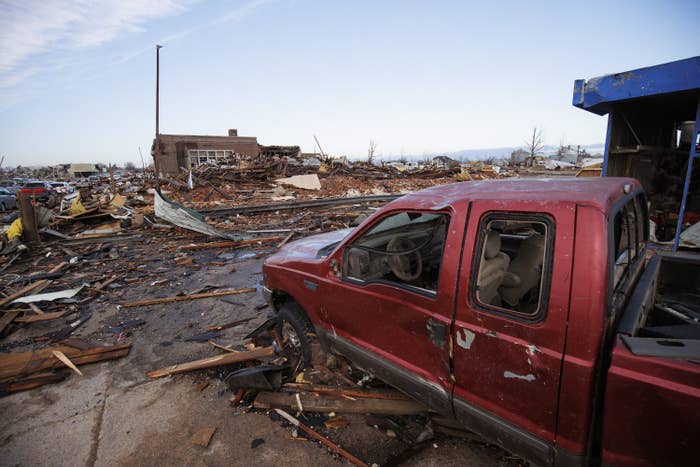 A truck sits amid a flattened landscape of rubble and debris