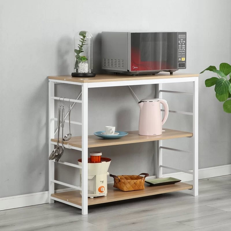 The rack in maple holing a microwave and kitchen supplies