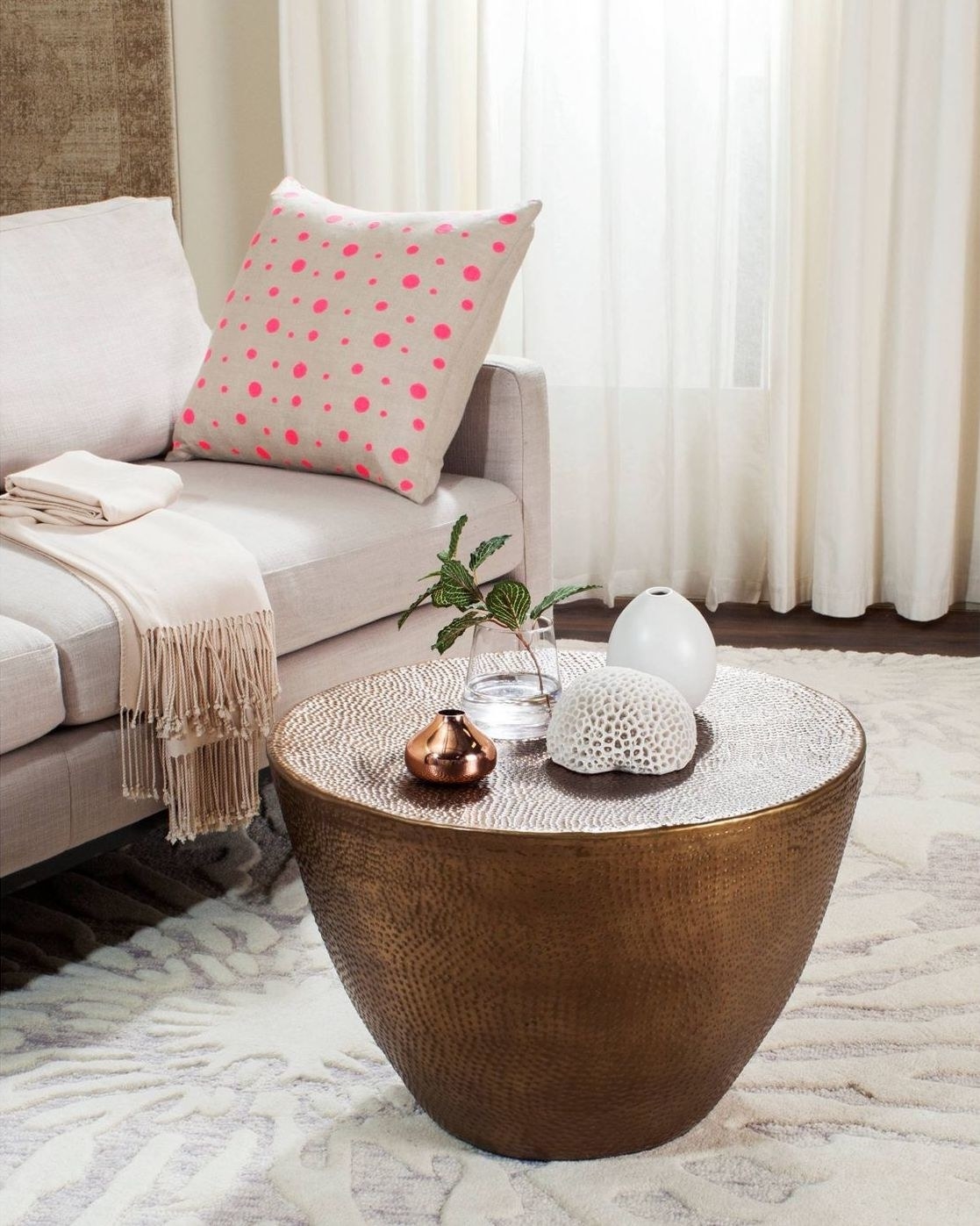 The circular gold brass coffee table in a living room