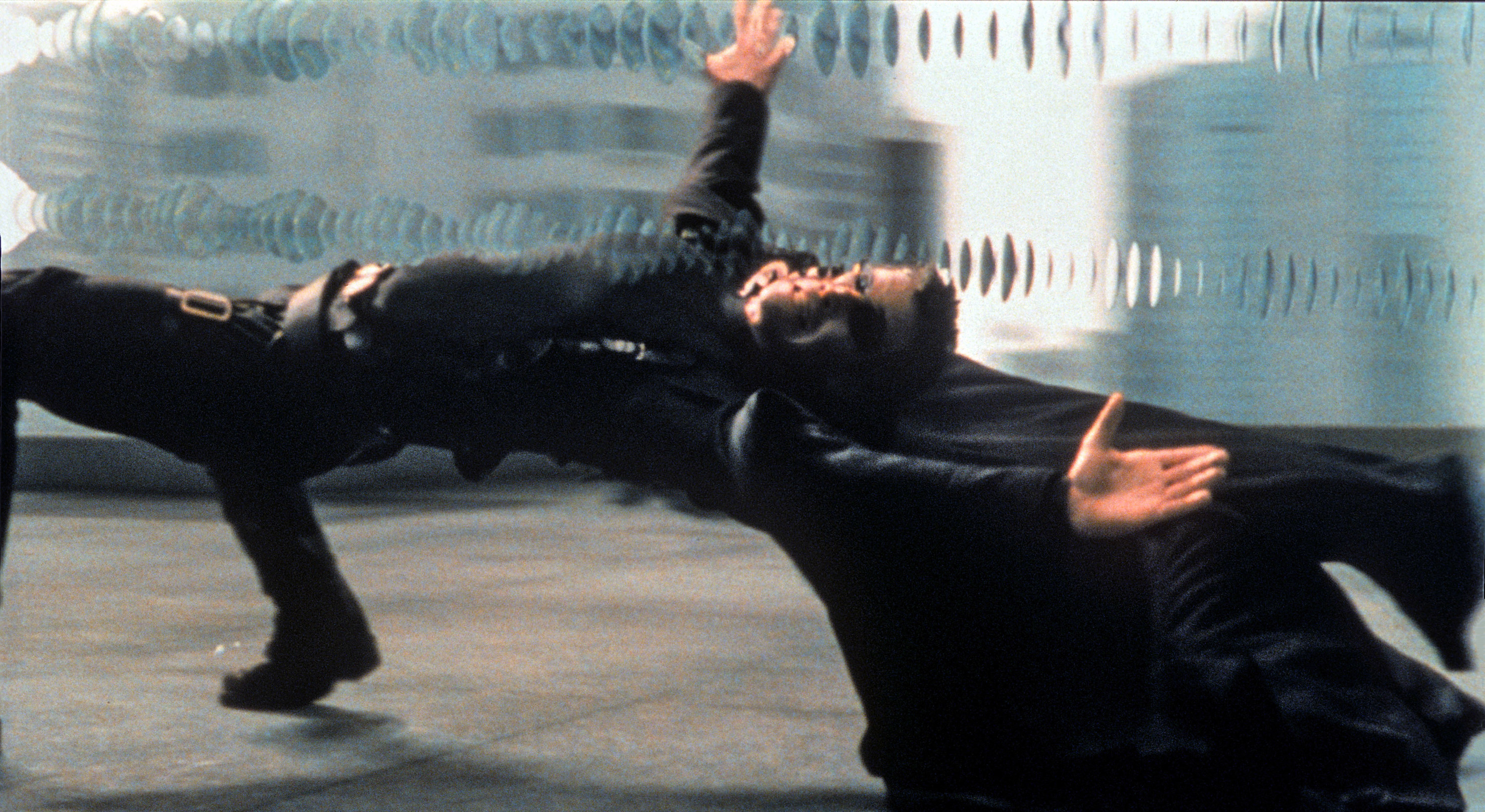 Keanu Reeves as Neo, bending backwards, dodging bullets in slow motion