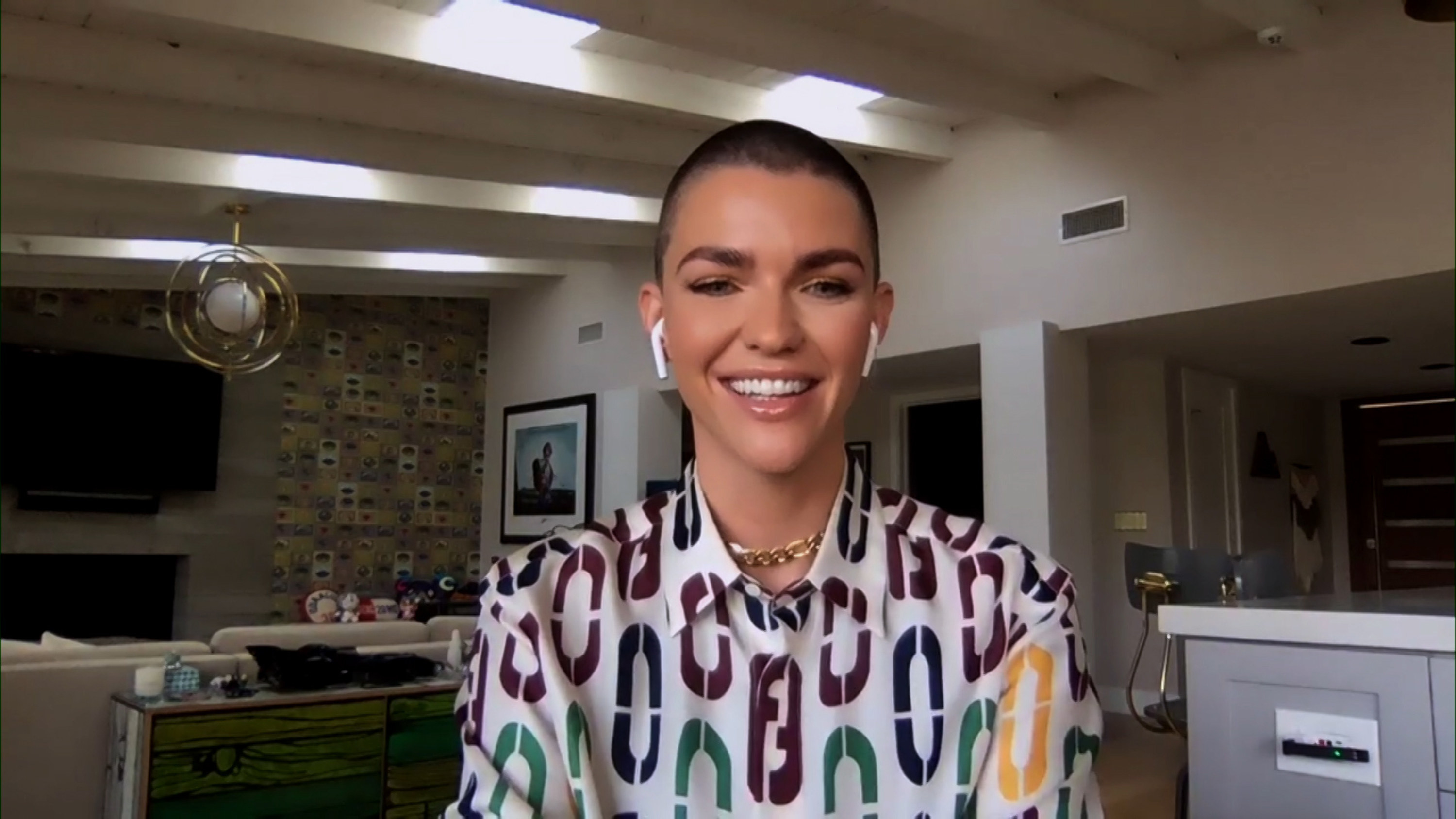 Ruby Rose sitting in a domestic setting, looking into the camera and smiling